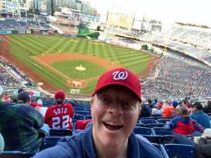 Man in cap takes selfie at baseball game